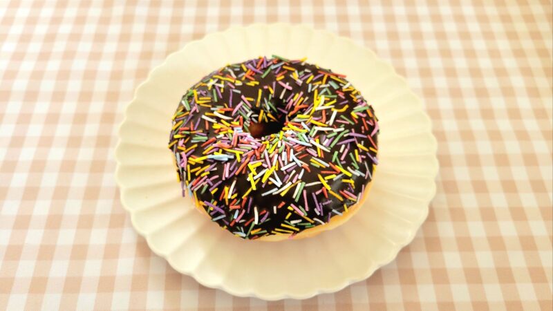 お皿に乗せられたチョココートスプリンクルドーナツ